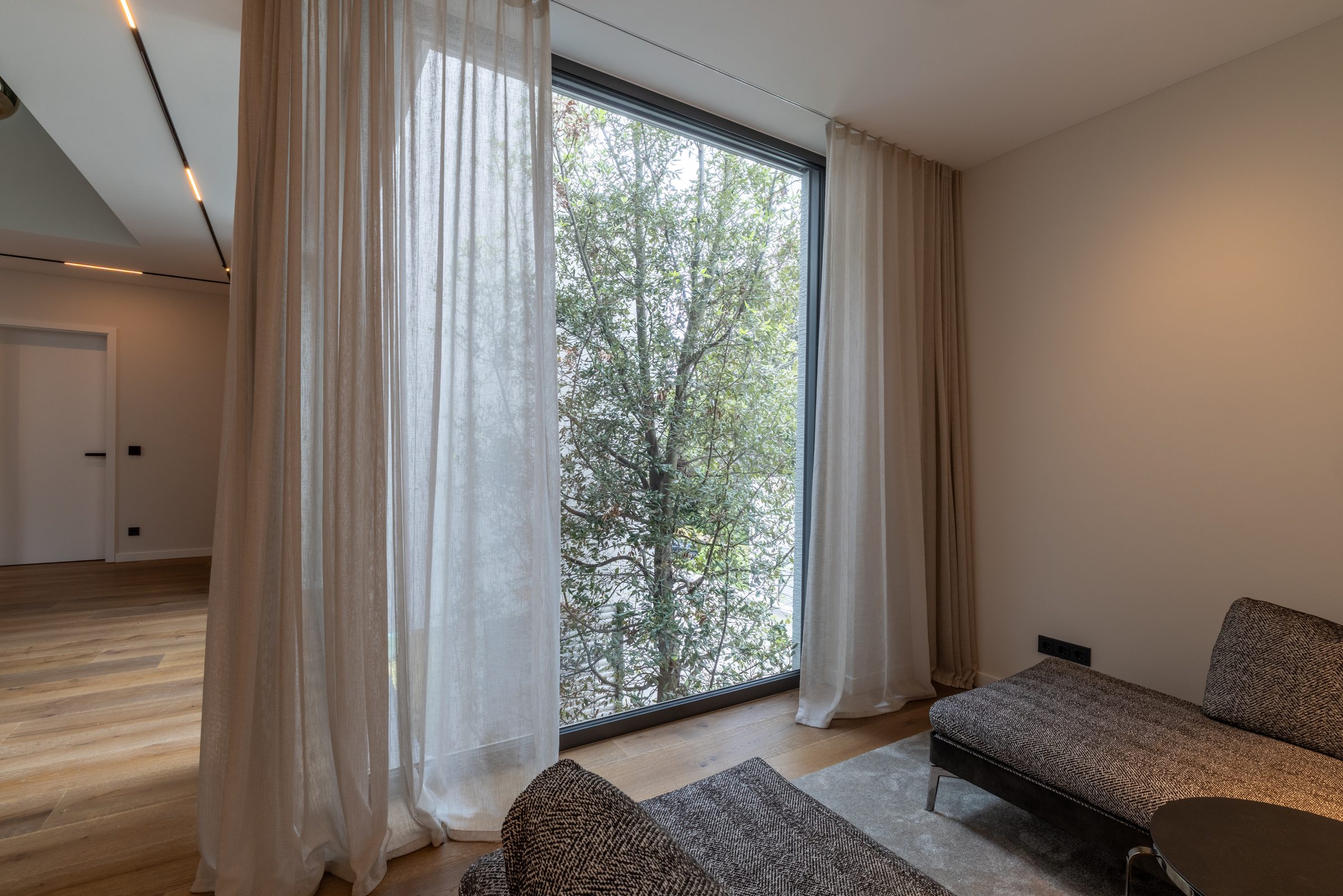 Zimmer mit bodentiefen Fenstern und Blick ins Grüne